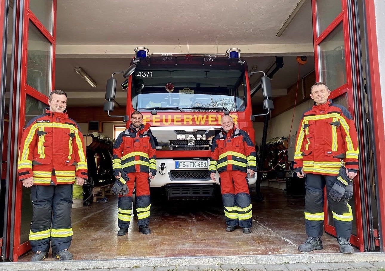 Aktive der Feuerwehr Kirchdorf in Einsatzkleidung vor dem Löschfahrzeug